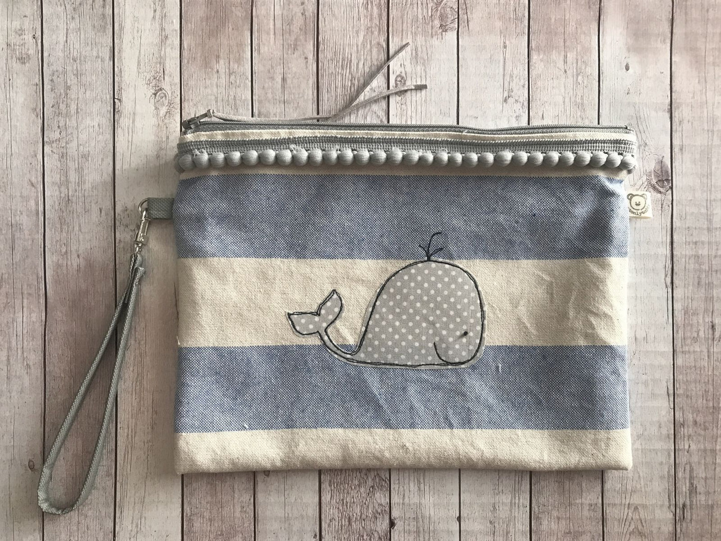 Pochette per la spiaggia a righe con pompon e manichetto con balenina