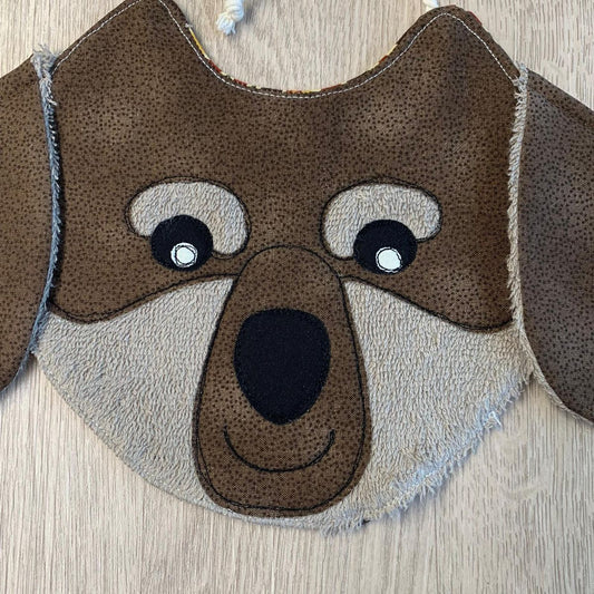 dettaglio di bavaglino a forma di musetto di bassotto