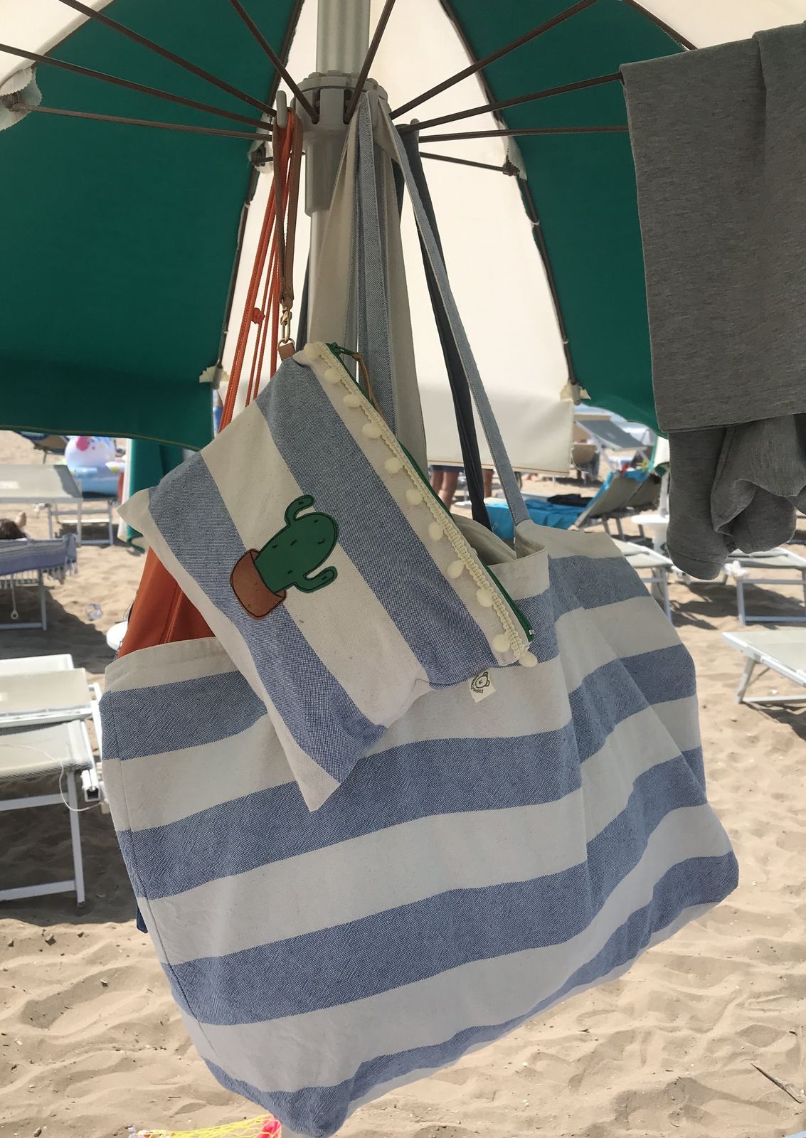 Pochette per la spiaggia a righe con pompon e manichetto con balenina