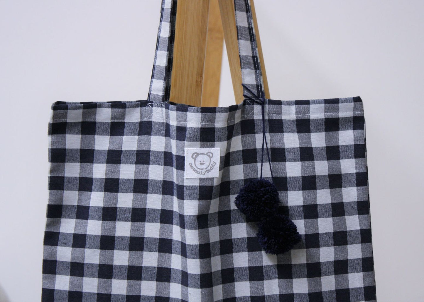 dettaglio pon pon blu su shopper bag a quadri blu