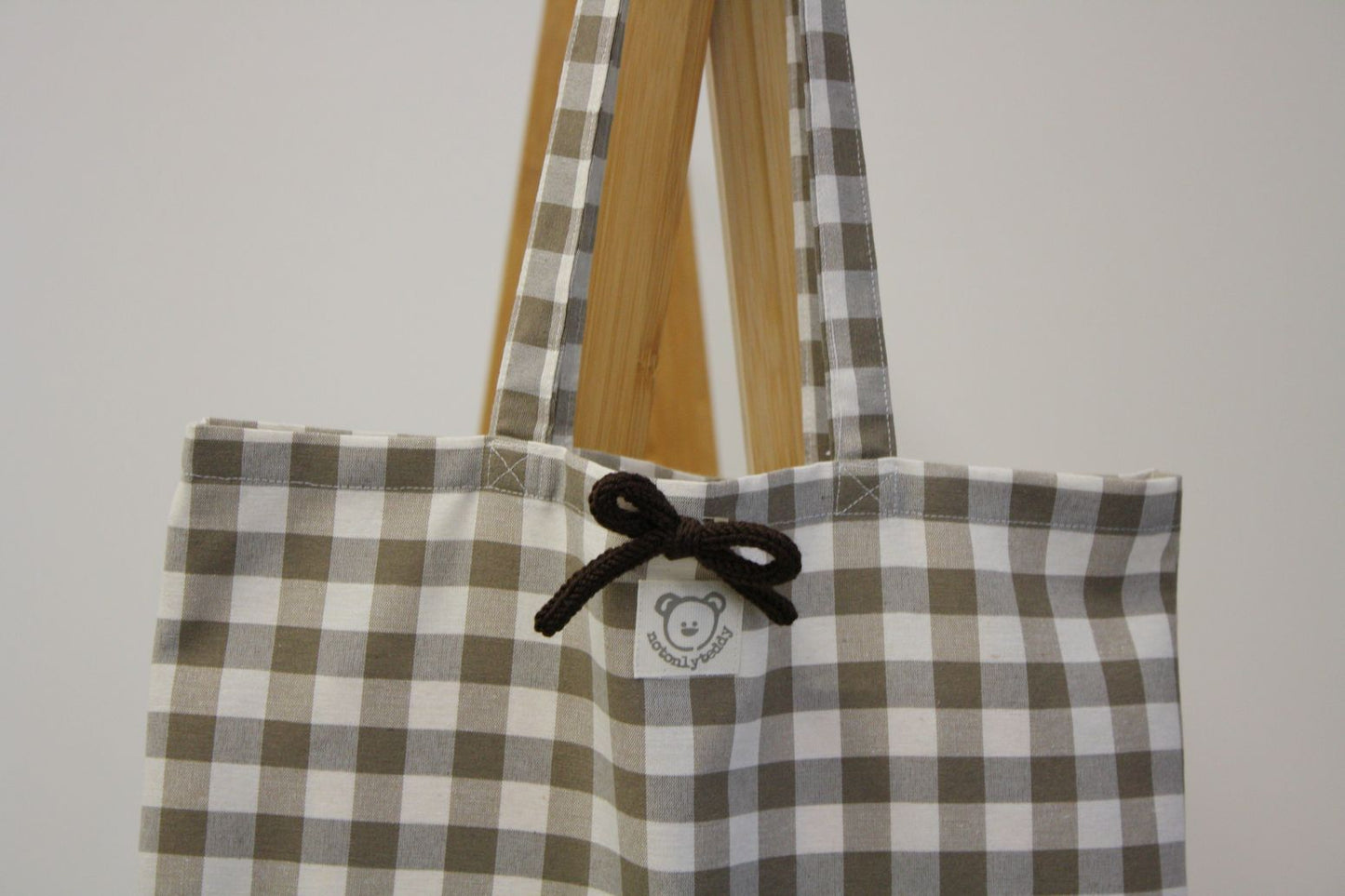 dettaglio fiocchetto marrone su shopper bag a quadri tortora