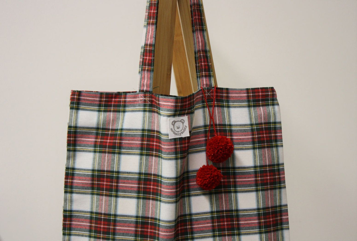 dettaglio- pom pon rossi di shopper donna tessuto tartan bianco