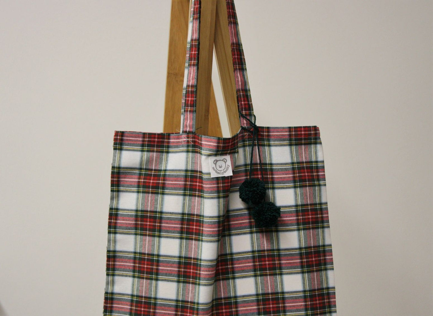 dettaglio pom pon verdi su shopper donna tessuto tartan bianco
