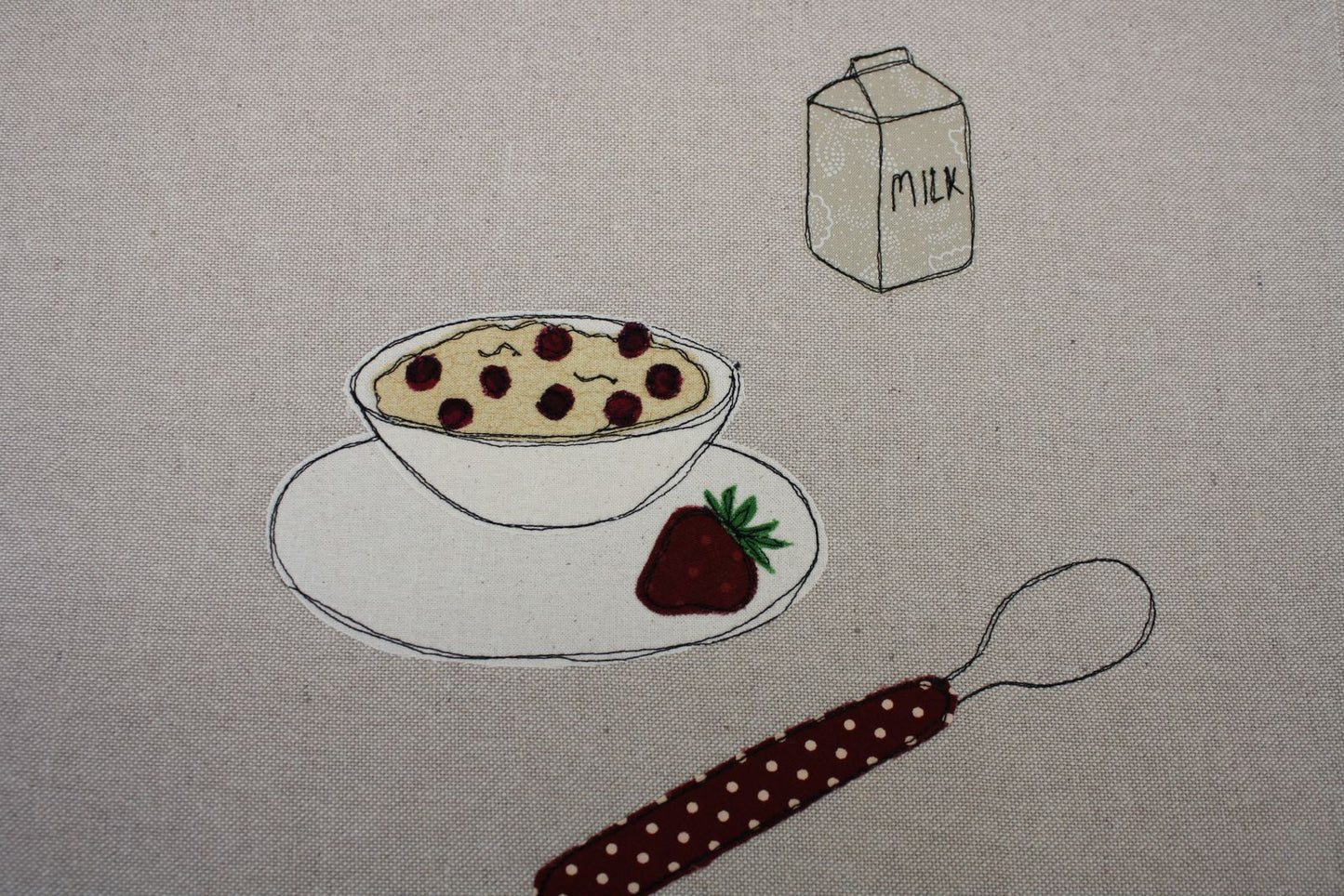 dettaglio ricamo porridge e latte su tovaglietta americana