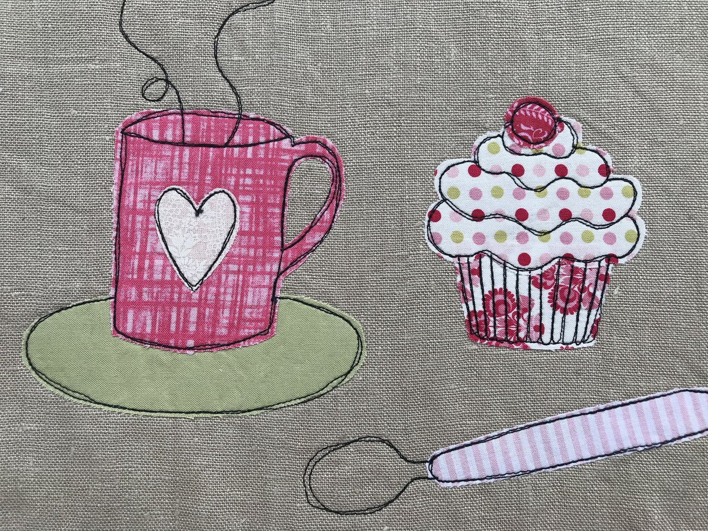 dettaglio ricamo cupcake, cucchiaino e mug fumante