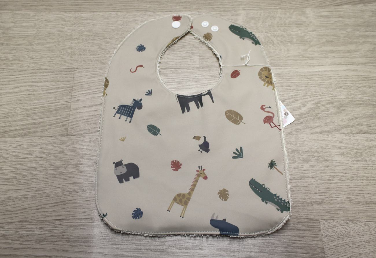 Bavaglino cerato con animaletti della savana su beige - retro in spugna