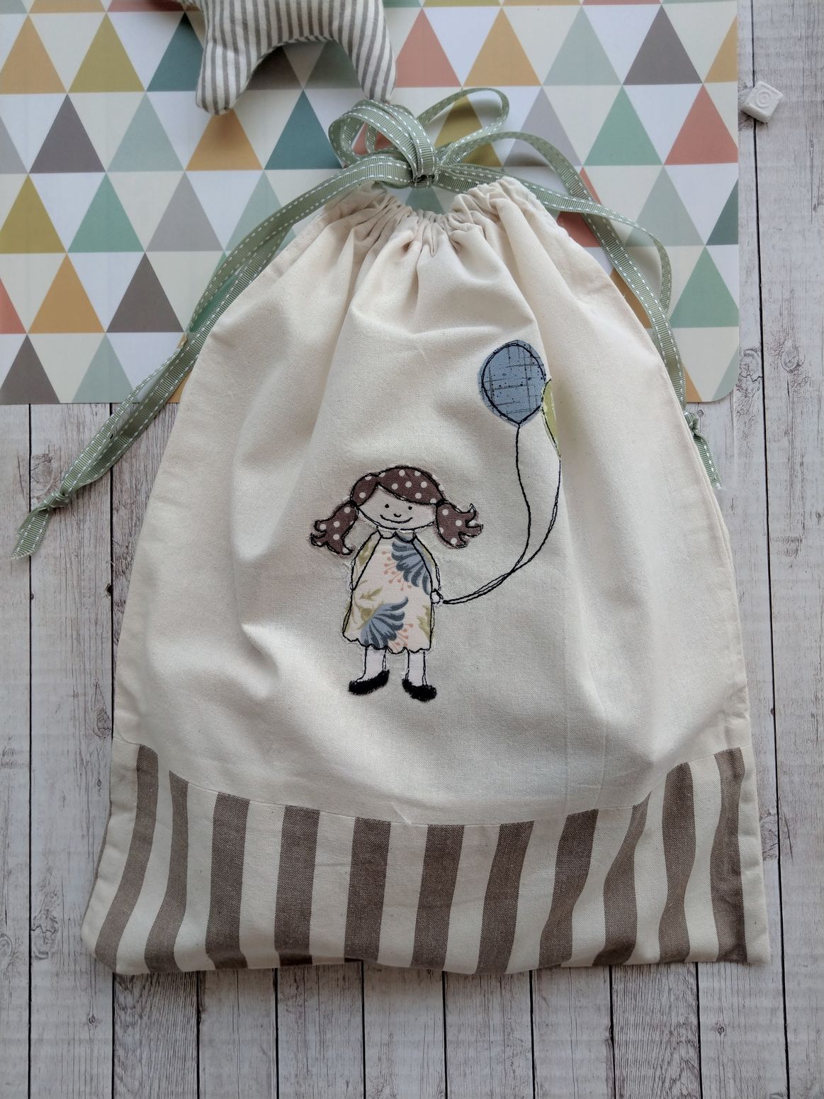Sacchetto in tessuto con ricamo di bambina con palloncini chiuso