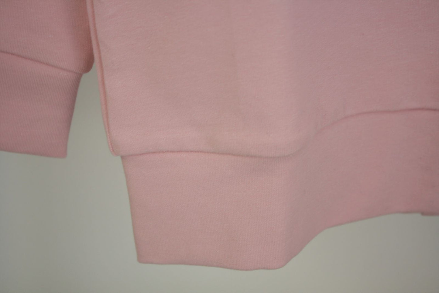 Dettaglio bordo di felpa garzata rosa con stella in tulle rosa glitterata