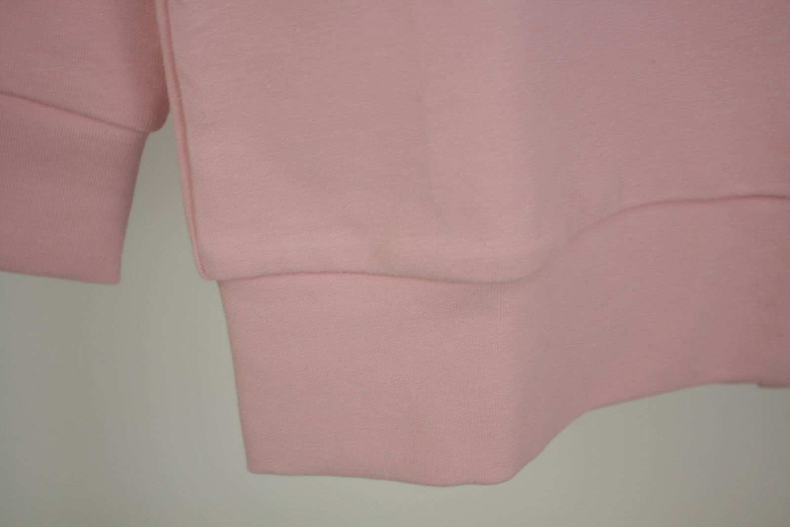 Dettaglio bordo di felpa garzata rosa con stella in tulle rosa glitterata