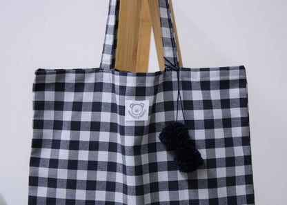 dettaglio pon pon blu su shopper bag a quadri blu