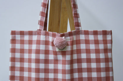 dettaglio spilla pon pon rosa su shopper donna quadri rosa antico