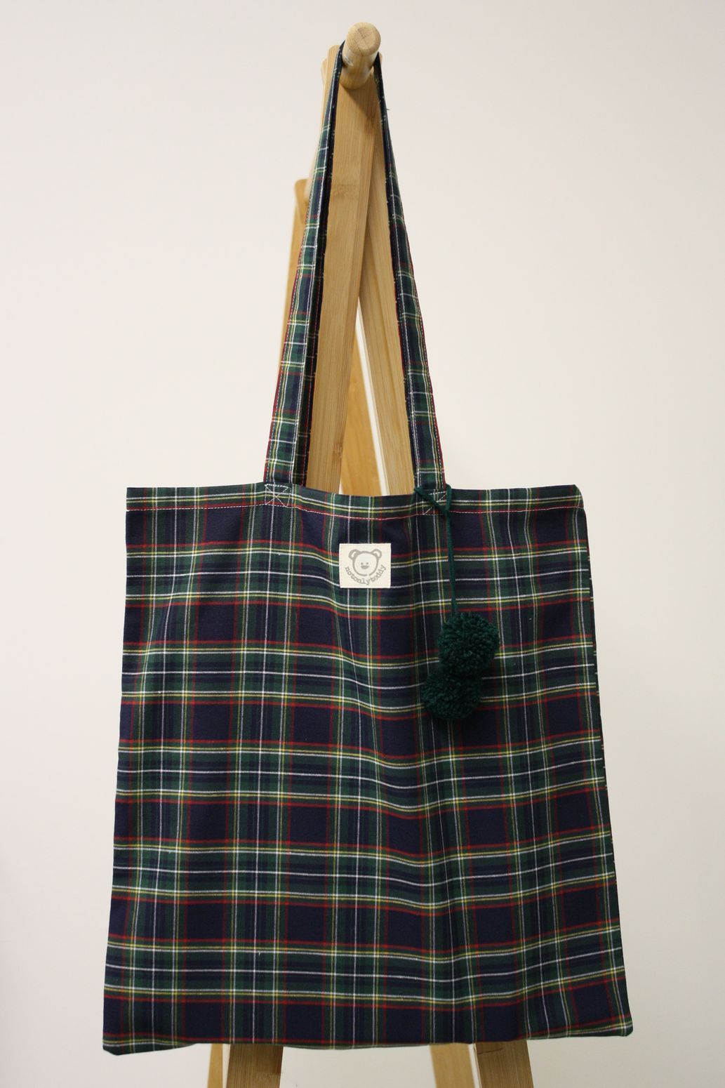 Shopper donna in tessuto scozzese blu con pom pon verdi
