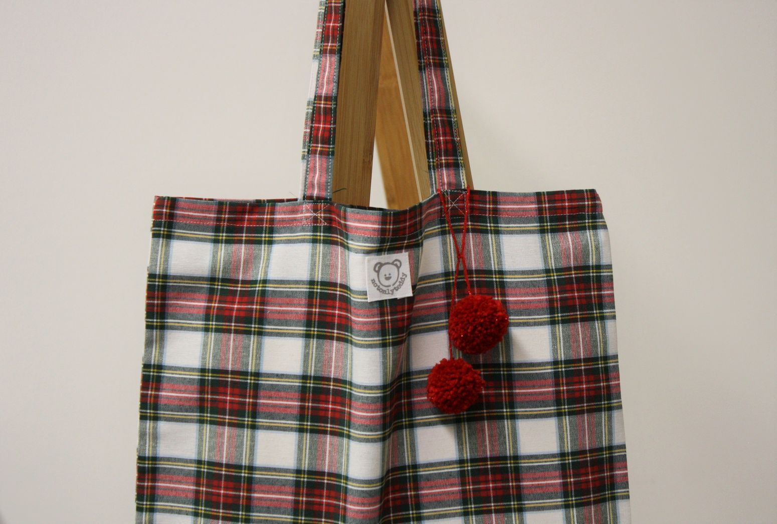 dettaglio- pom pon rossi di shopper donna tessuto tartan bianco