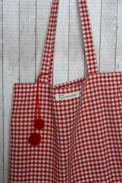 Dettaglio pom pon rossi su shopper tela quadretti rossi